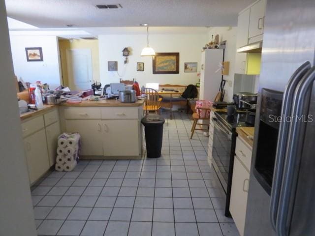 kitchen featuring visible vents, light tile patterned flooring, stainless steel appliances, light countertops, and white cabinetry