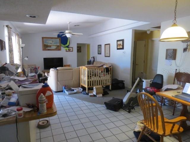 living room with lofted ceiling, light tile patterned flooring, and a ceiling fan