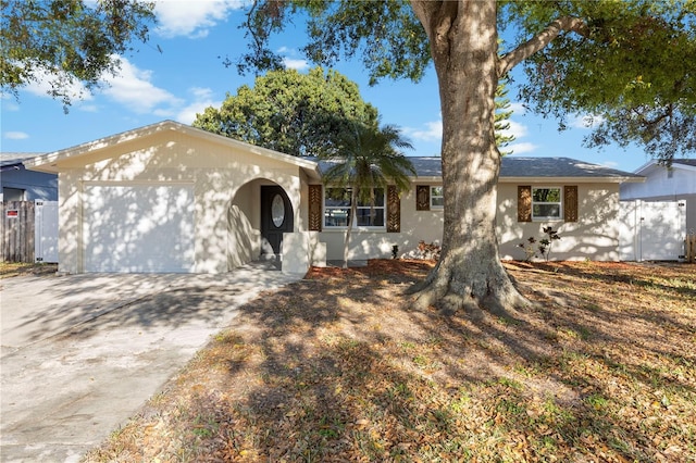 ranch-style home with an attached garage, fence, and driveway