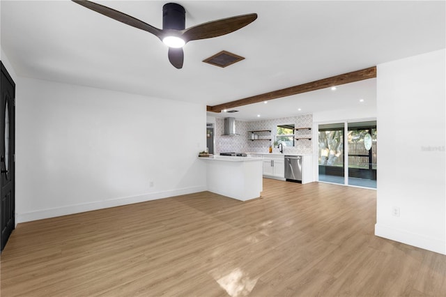 unfurnished living room with baseboards, beam ceiling, light wood-style flooring, and a ceiling fan