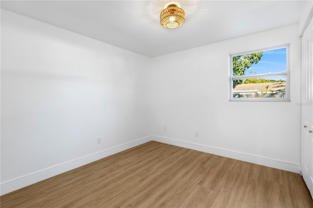 unfurnished room with baseboards and wood finished floors