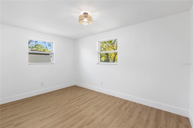 unfurnished room featuring baseboards and light wood finished floors