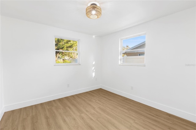 unfurnished room with baseboards and light wood-style flooring