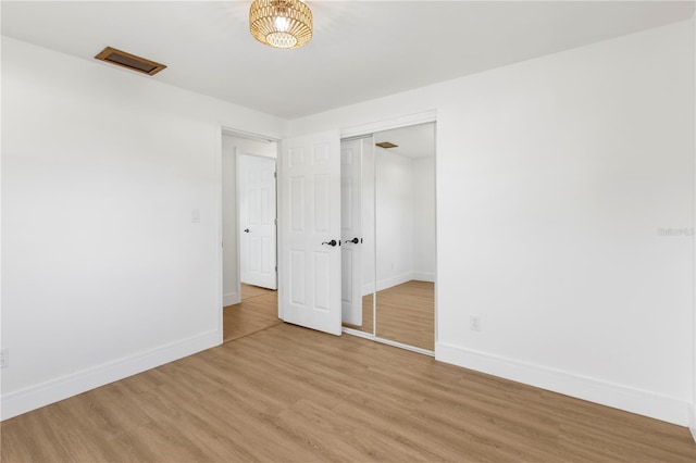 empty room featuring baseboards and light wood finished floors