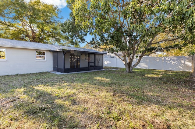 view of yard featuring a fenced backyard and a sunroom