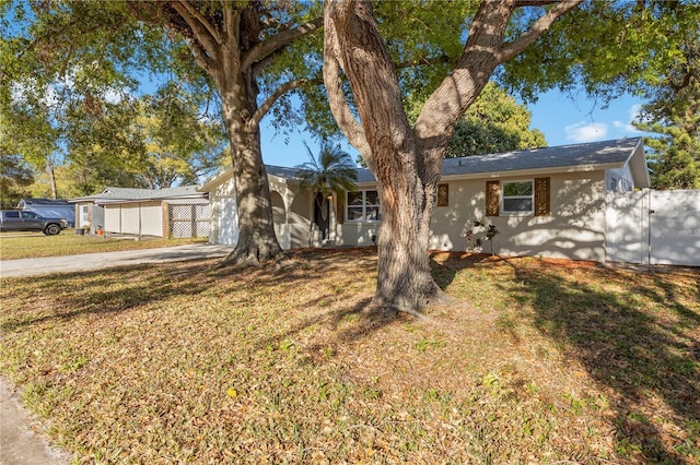 single story home featuring a front yard, fence, driveway, and stucco siding