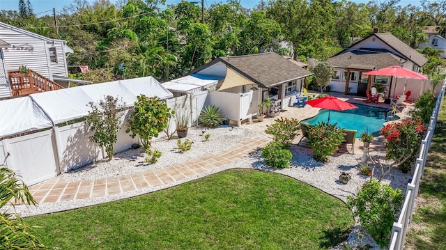 exterior space featuring a fenced in pool, a lawn, an outdoor structure, a fenced backyard, and a patio area