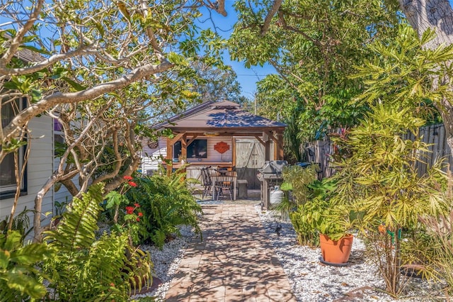 view of front of property with a gazebo, roof with shingles, and a patio area