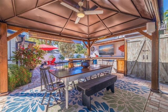 view of patio with a gazebo, outdoor dining space, and fence