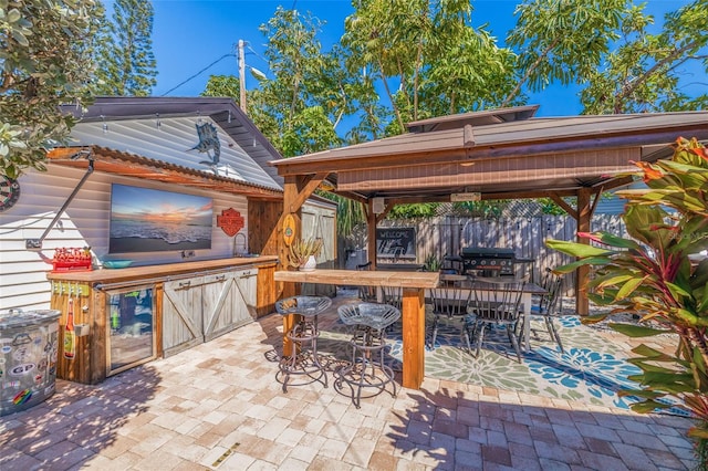 view of patio featuring a gazebo, outdoor dining area, and fence