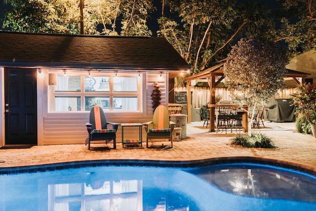 outdoor pool with an outbuilding, a patio, fence, a gazebo, and grilling area