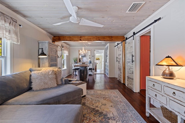 living room with visible vents, ceiling fan, dark wood-type flooring, crown molding, and a barn door