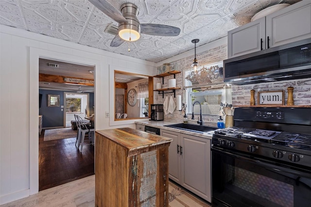 kitchen with gas stove, stainless steel microwave, an ornate ceiling, and a sink