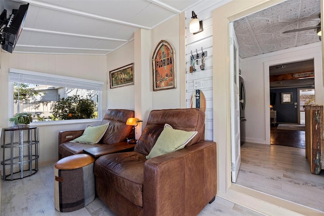 sitting room with wooden walls and wood finished floors