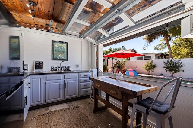 view of patio / terrace with fence, outdoor wet bar, and a sink