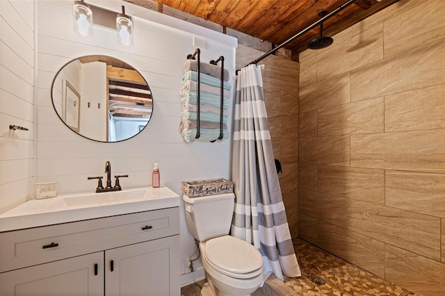 bathroom with toilet, wooden ceiling, vanity, and a tile shower