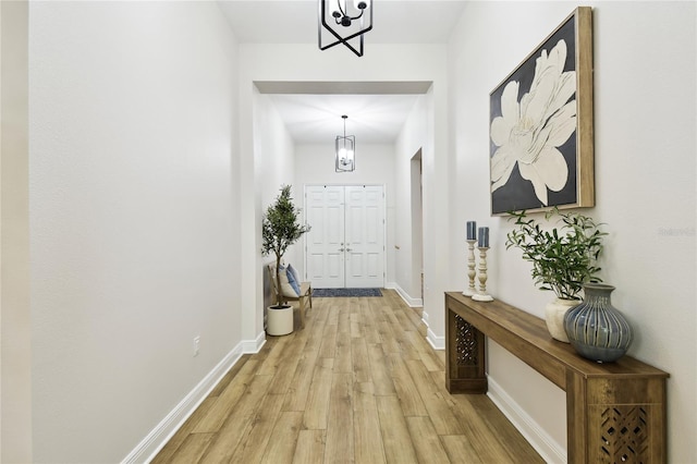 8766 Shadyside Ln, Land O Lakes, FL 34637 - entryway featuring light wood-type flooring, a chandelier, and baseboards