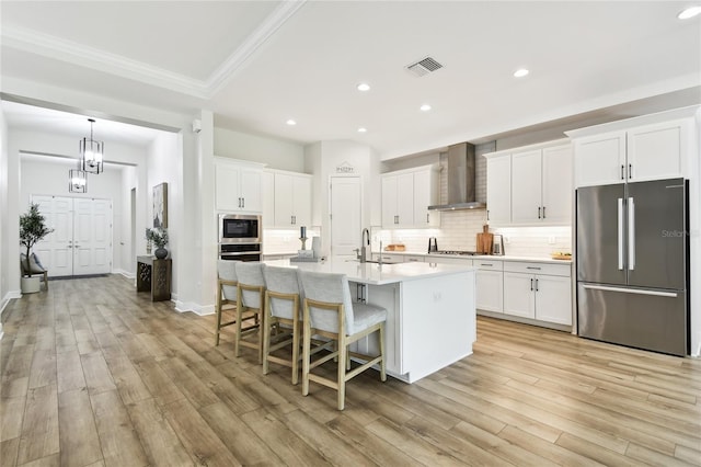 8766 Shadyside Ln, Land O Lakes, FL 34637 - kitchen with appliances with stainless steel finishes, wall chimney exhaust hood, white cabinets, recessed lighting, and light wood-style floors