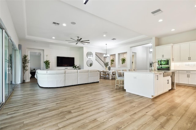 8766 Shadyside Ln, Land O Lakes, FL 34637 - kitchen with open floor plan, an island with sink, light countertops, light wood-style floors, and recessed lighting