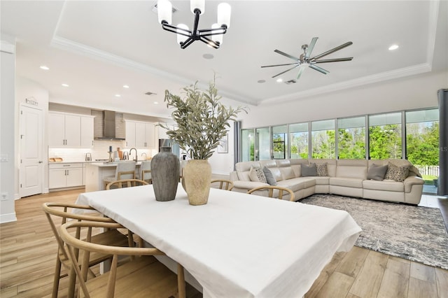 8766 Shadyside Ln, Land O Lakes, FL 34637 - dining space featuring a chandelier, ornamental molding, recessed lighting, light wood-style floors, and a raised ceiling