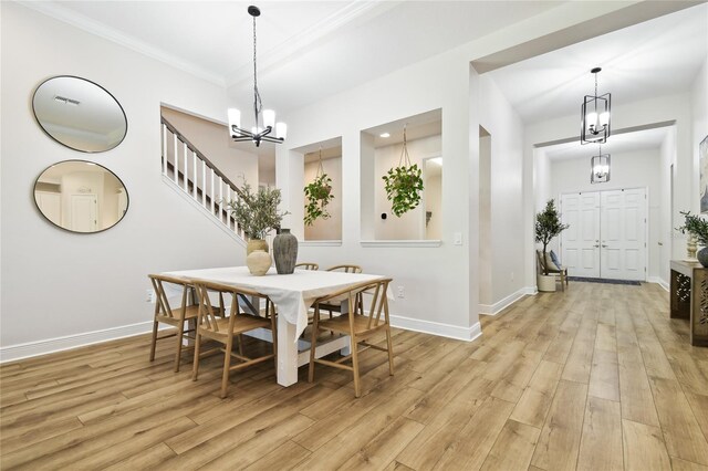 8766 Shadyside Ln, Land O Lakes, FL 34637 - dining room featuring a chandelier, light wood-type flooring, baseboards, and ornamental molding