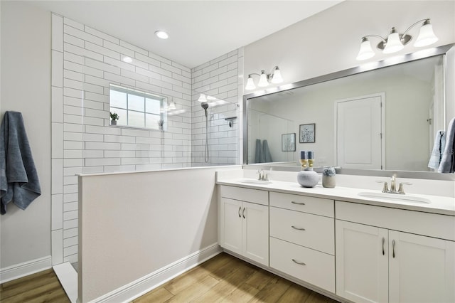 8766 Shadyside Ln, Land O Lakes, FL 34637 - bathroom featuring double vanity, a walk in shower, wood finished floors, and baseboards