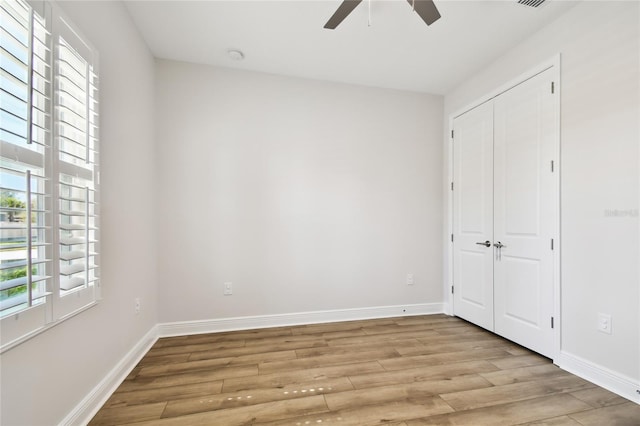 8766 Shadyside Ln, Land O Lakes, FL 34637 - unfurnished bedroom featuring light wood-style floors, baseboards, a closet, and a ceiling fan