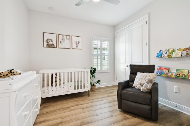 8766 Shadyside Ln, Land O Lakes, FL 34637 - bedroom featuring a crib, light wood-type flooring, and baseboards