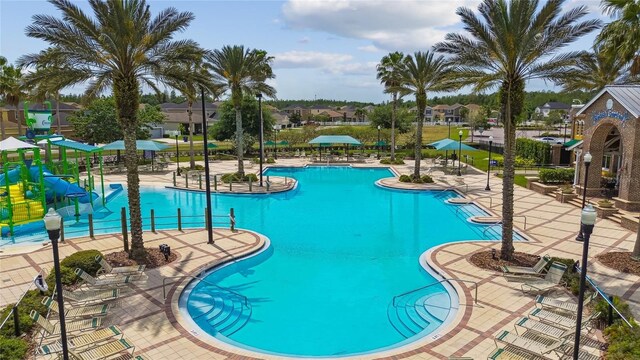 8766 Shadyside Ln, Land O Lakes, FL 34637 - community pool featuring a water slide, a patio, and a residential view