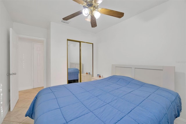 bedroom with light tile patterned floors, visible vents, a closet, and ceiling fan