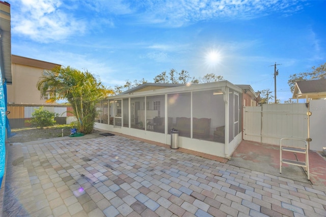 view of patio with a fenced backyard and a sunroom