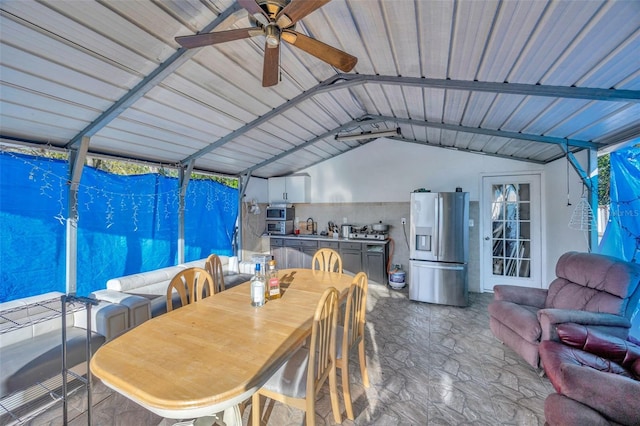 dining space featuring lofted ceiling, a ceiling fan, and a sunroom