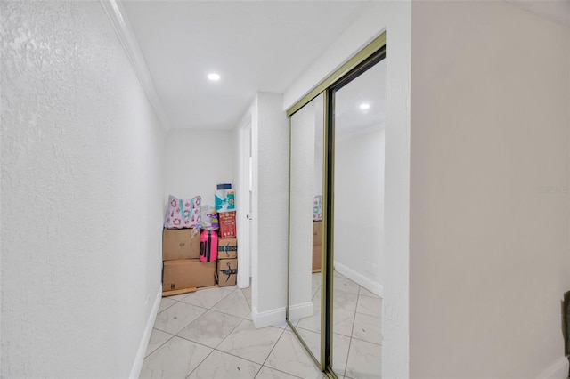 hallway featuring a textured wall, baseboards, and marble finish floor