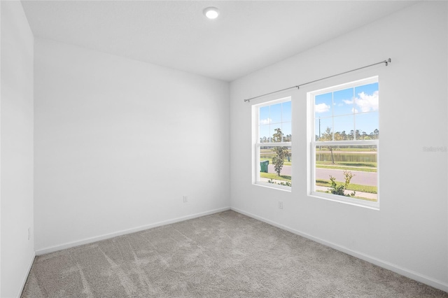 carpeted spare room with baseboards