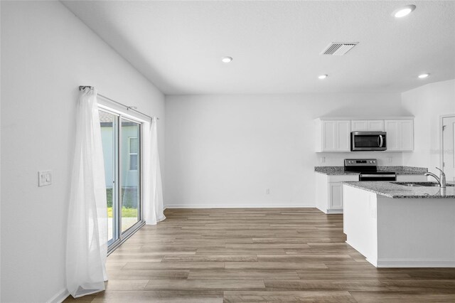 kitchen with visible vents, stainless steel appliances, light wood-style floors, white cabinetry, and a sink