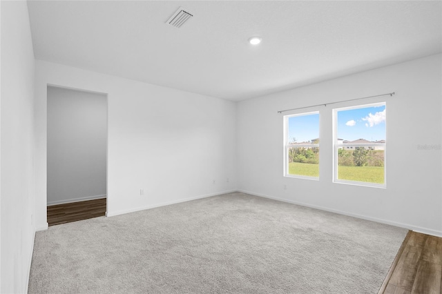 spare room featuring carpet flooring, baseboards, and visible vents