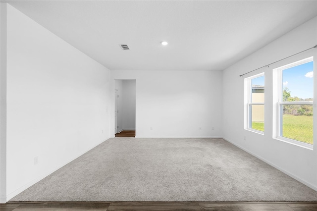 carpeted spare room with baseboards and visible vents