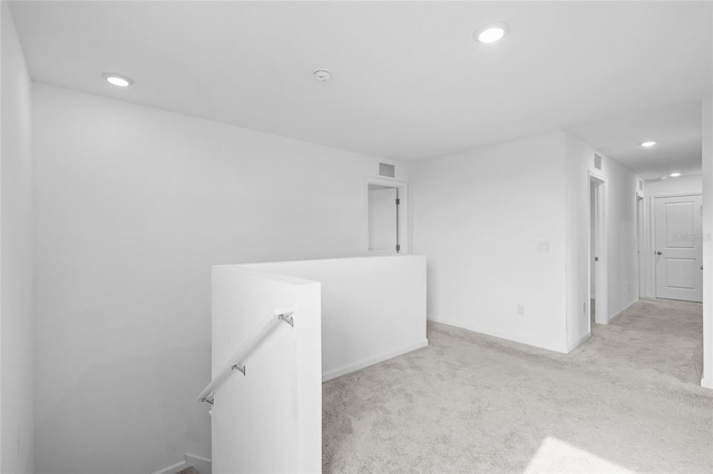 unfurnished room featuring light carpet, visible vents, recessed lighting, and baseboards