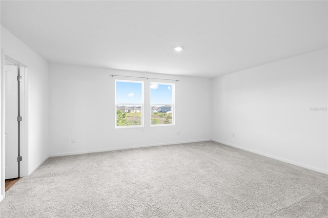 unfurnished room with baseboards and carpet floors