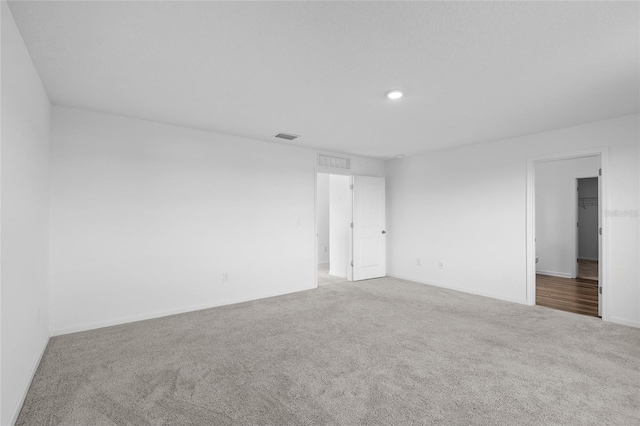 carpeted empty room featuring recessed lighting, baseboards, and visible vents