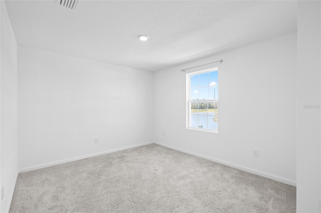 empty room with visible vents, baseboards, and carpet floors