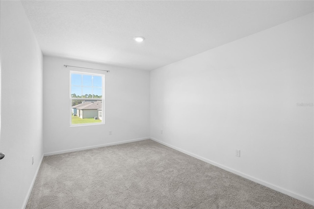 spare room featuring baseboards and carpet floors