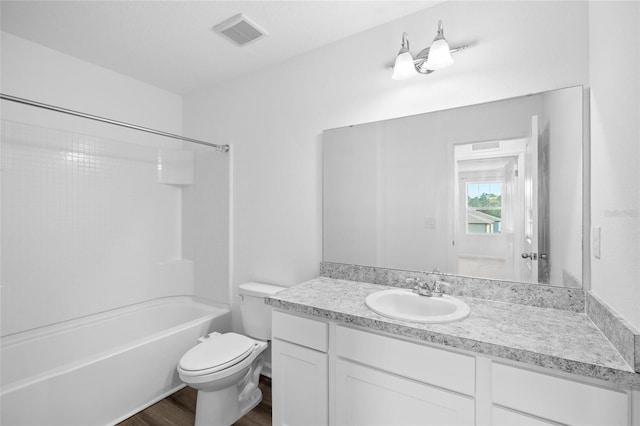 bathroom featuring visible vents, toilet, shower / bathing tub combination, wood finished floors, and vanity