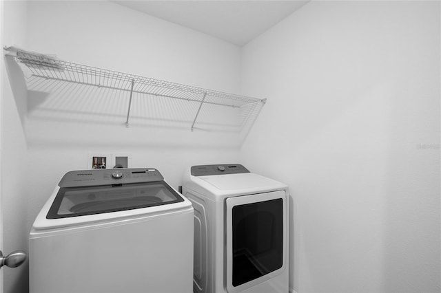 washroom with washing machine and clothes dryer and laundry area