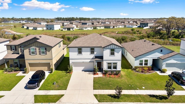 view of front of property with an attached garage, board and batten siding, a front lawn, a residential view, and driveway