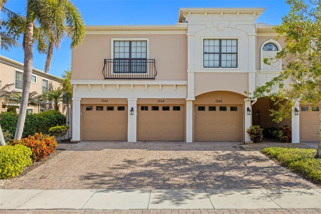 view of front facade with decorative driveway, a garage, and stucco siding