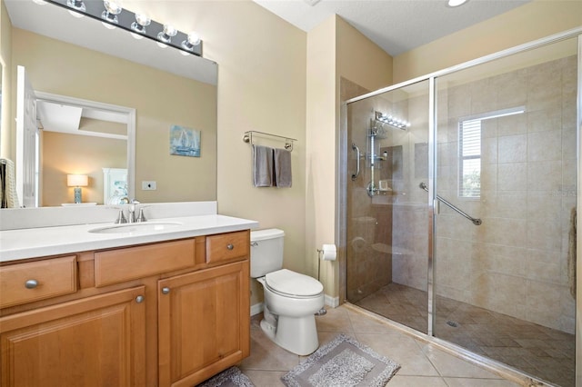 bathroom featuring vanity, baseboards, a stall shower, tile patterned flooring, and toilet