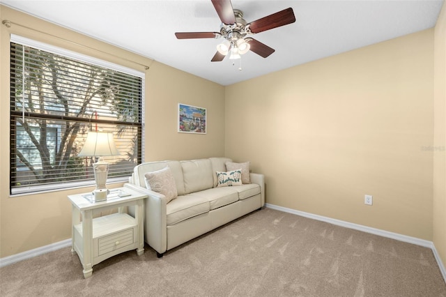 sitting room featuring baseboards, ceiling fan, and carpet flooring