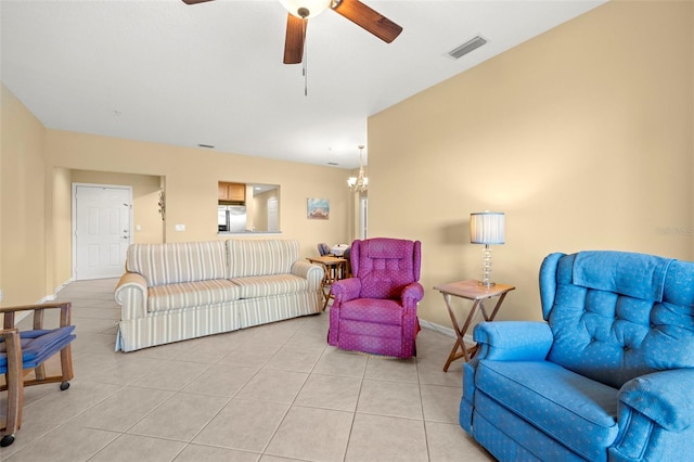 living area featuring light tile patterned floors, visible vents, and ceiling fan with notable chandelier