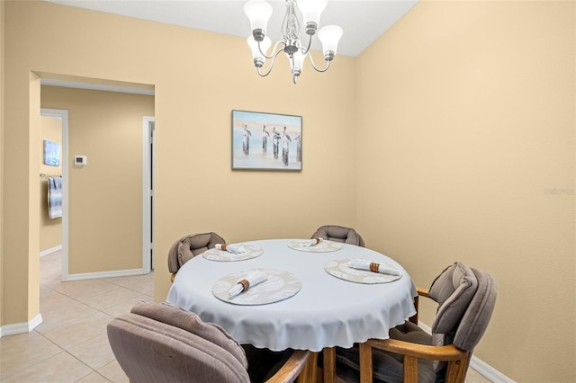 dining space featuring a notable chandelier, baseboards, and light tile patterned floors